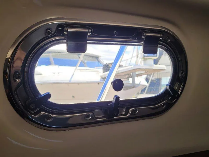 Slide: The Image of Porthole view from 2013 Pursuit 345 OS Offshore boat, showcasing marina scene. - 27