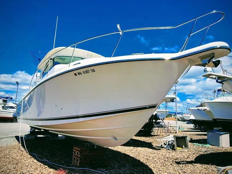 Slide: The Image of 2013 Pursuit 345 OS Offshore boat on dry dock under clear blue sky. - 3