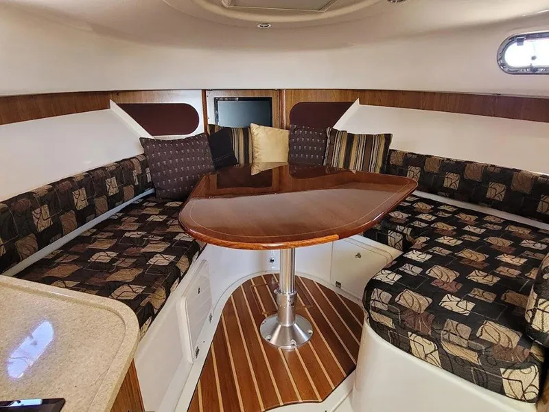 Slide: The Image of 2013 Pursuit 345 OS Offshore cabin with elegant seating and wooden table. - 30
