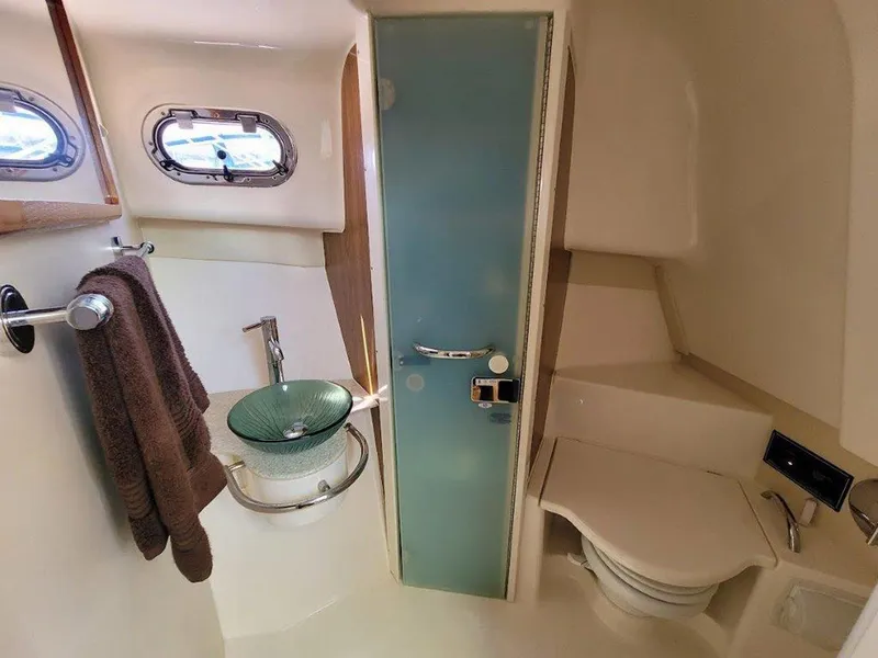 Slide: The Image of 2013 Pursuit 345 OS Offshore boat bathroom with modern fixtures and glass sink. - 34