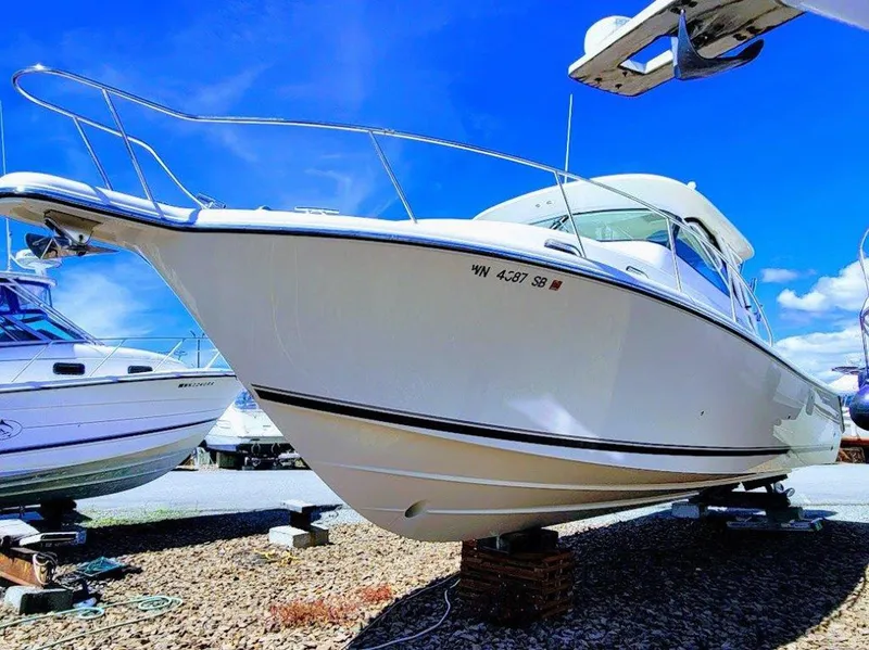 Slide: The Image of 2013 Pursuit 345 OS Offshore boat on dry dock under clear blue sky. - 4