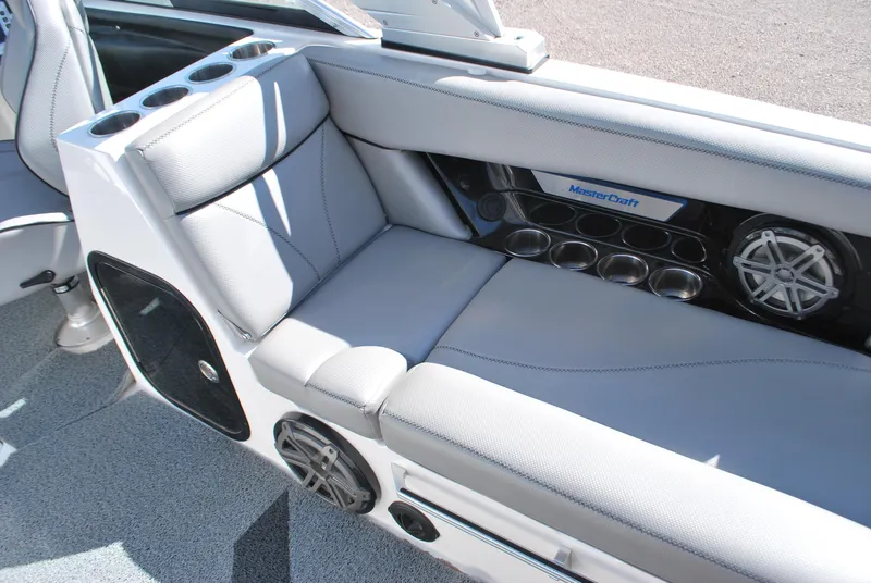 Slide: The Image of 2016 MasterCraft X26 boat interior with gray seating and built-in speakers. - 10