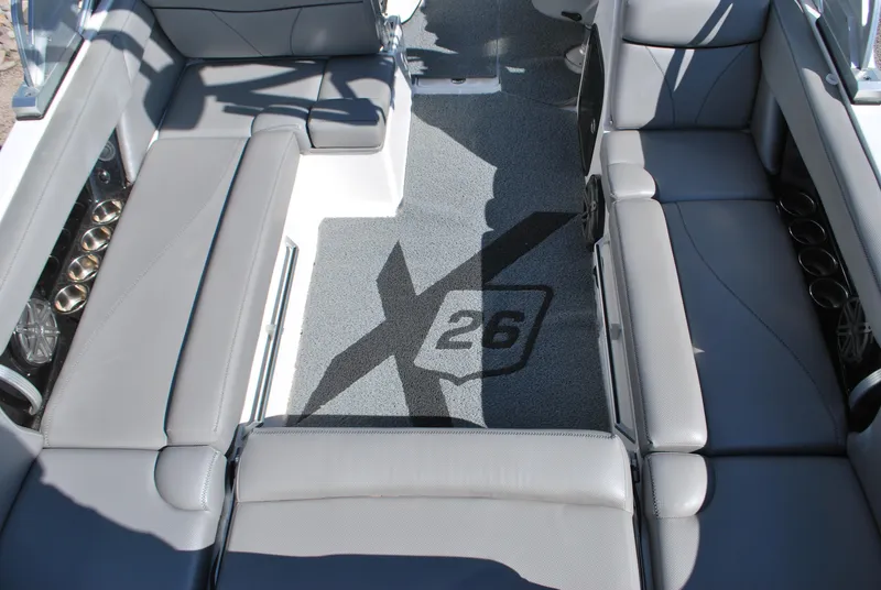 Slide: The Image of 2016 MasterCraft X26 boat interior with gray seating and logo on carpet. - 14