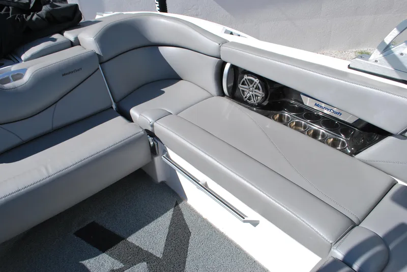 Slide: The Image of 2016 MasterCraft X26 boat interior with gray seating and speaker system. - 15
