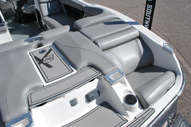 Slide: The Image of 2016 MasterCraft X26 boat interior with gray seating and cup holder. - 18