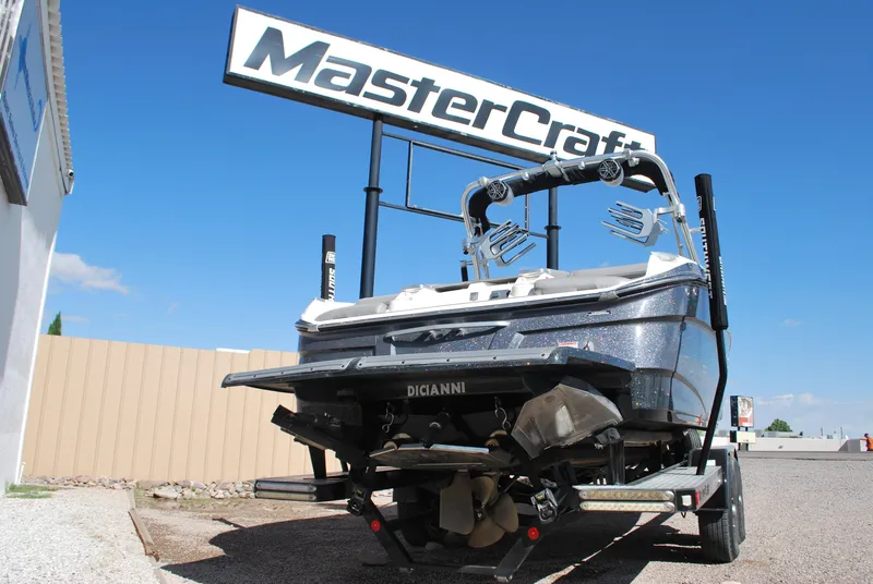Slide: The Image of 2016 MasterCraft X26 boat on trailer under dealership sign. - 21