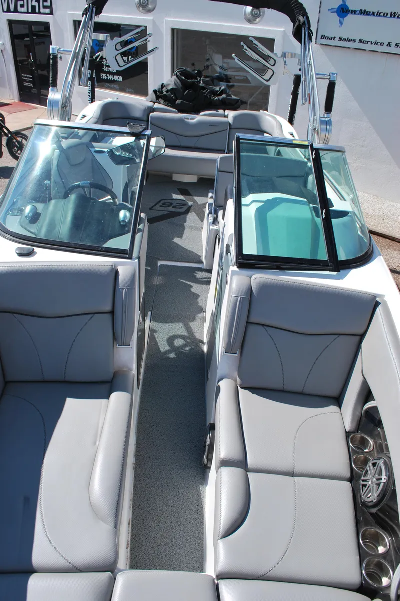Slide: The Image of 2016 MasterCraft X26 boat interior with gray seating and glass windshields. - 3