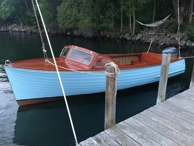 The Image of 1956 Lyman 18 Outboard boat docked on a serene lake. - 0