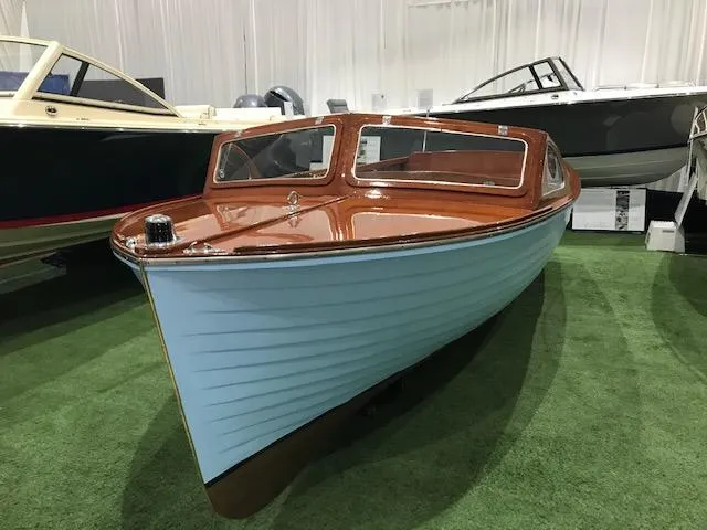 Slide: The Image of 1956 Lyman 18 Outboard boat with blue hull and wooden deck on display indoors. - 3