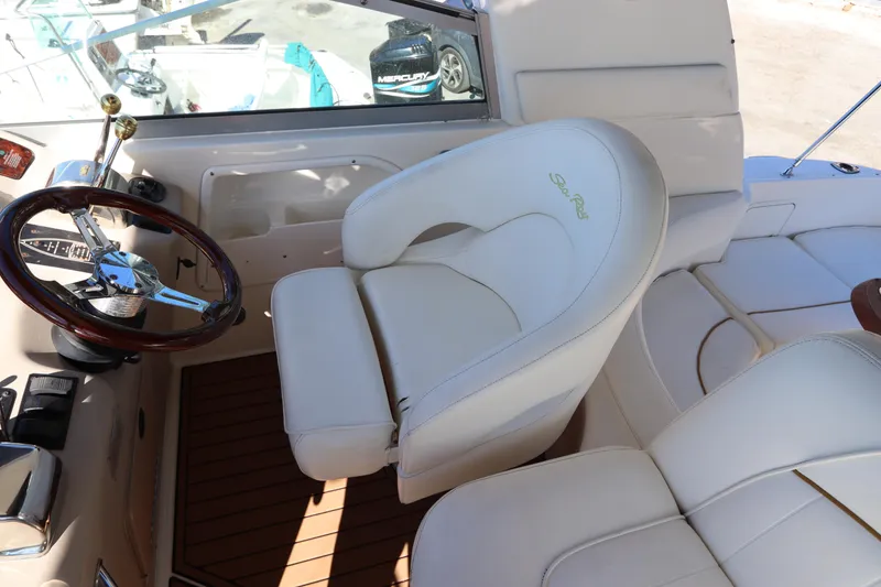 Slide: The Image of 2001 Sea Ray 310 Sundancer helm with white leather seat and wooden steering wheel. - 14
