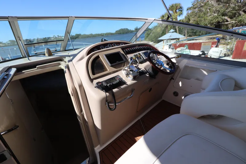 Slide: The Image of 2001 Sea Ray 310 Sundancer helm with steering wheel and navigation controls. - 15