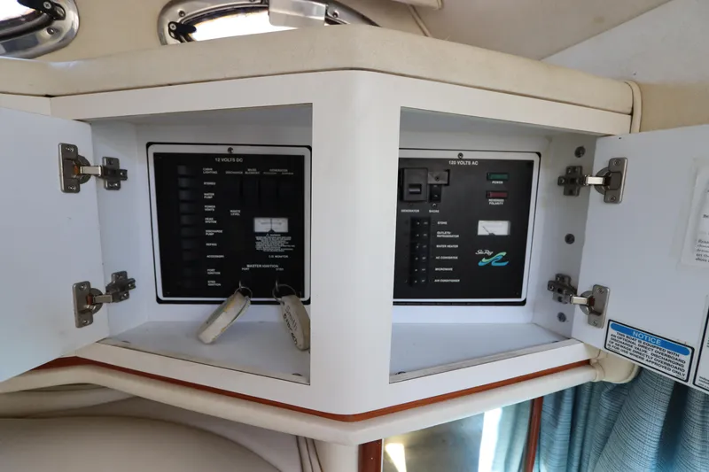 Slide: The Image of Electrical panel inside 2001 Sea Ray 310 Sundancer boat, open cabinet view. - 28