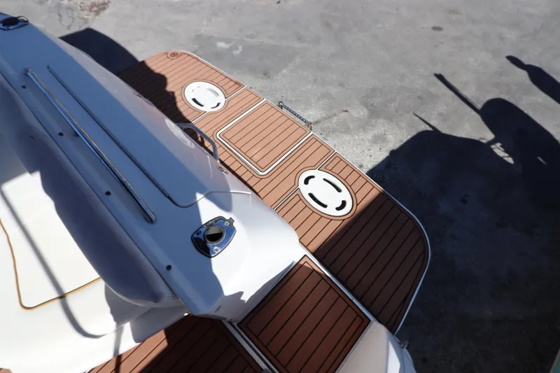 Slide: The Image of 2001 Sea Ray 310 Sundancer boat deck with wood finish and metal railings. - 3