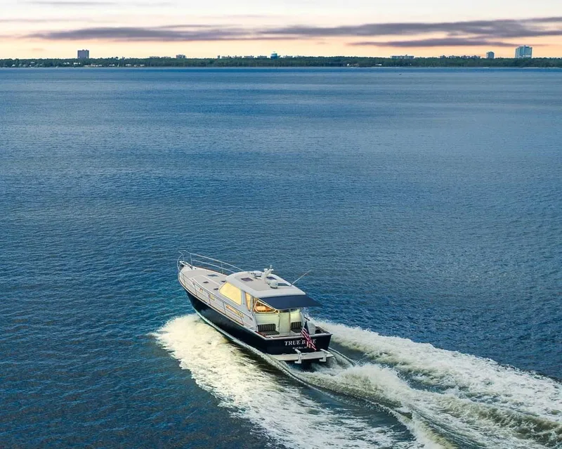 Slide: The Image of 2005 Sabre 42 Express yacht cruising on open water at sunset. - 26