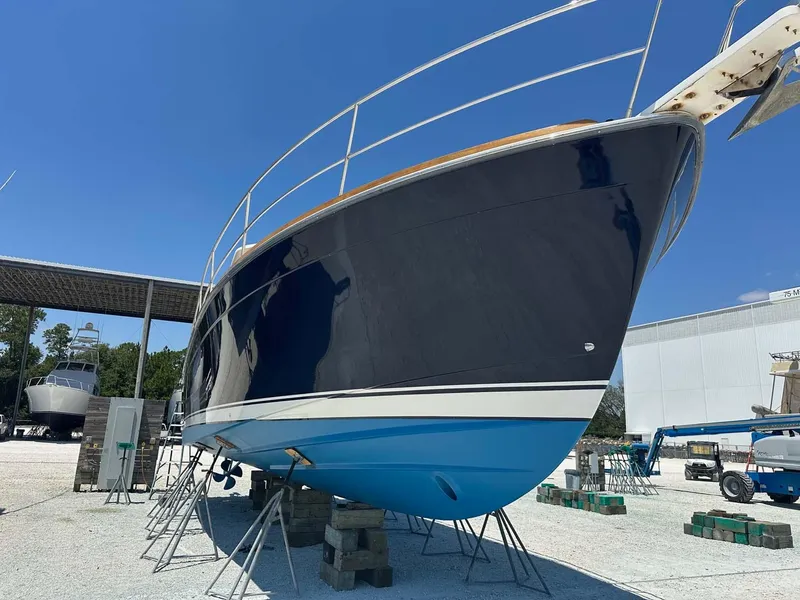 Slide: The Image of 2005 Sabre 42 Express boat on stands, blue hull, outdoor storage. - 35