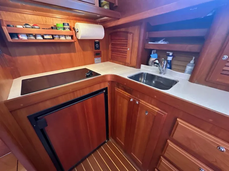 Slide: The Image of 2005 Sabre 42 Express yacht kitchen with wood cabinetry, sink, and stove. - 4