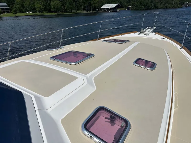 Slide: The Image of 2005 Sabre 42 Express yacht deck with pink hatches on a serene lake. - 6