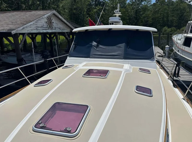 Slide: The Image of 2005 Sabre 42 Express yacht docked, featuring multiple deck hatches and a covered cockpit. - 7