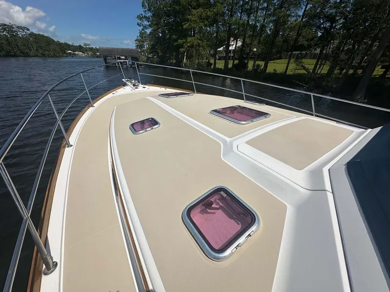 Slide: The Image of 2005 Sabre 42 Express yacht deck with hatches, cruising on a serene river. - 8