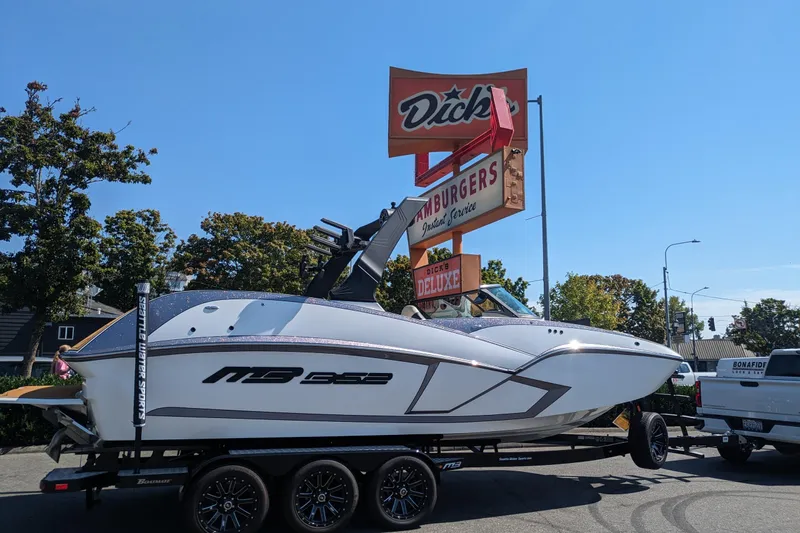 The Image of 2025 MB B52 25 Alpha boat on trailer near Dick's Hamburgers sign. - 0