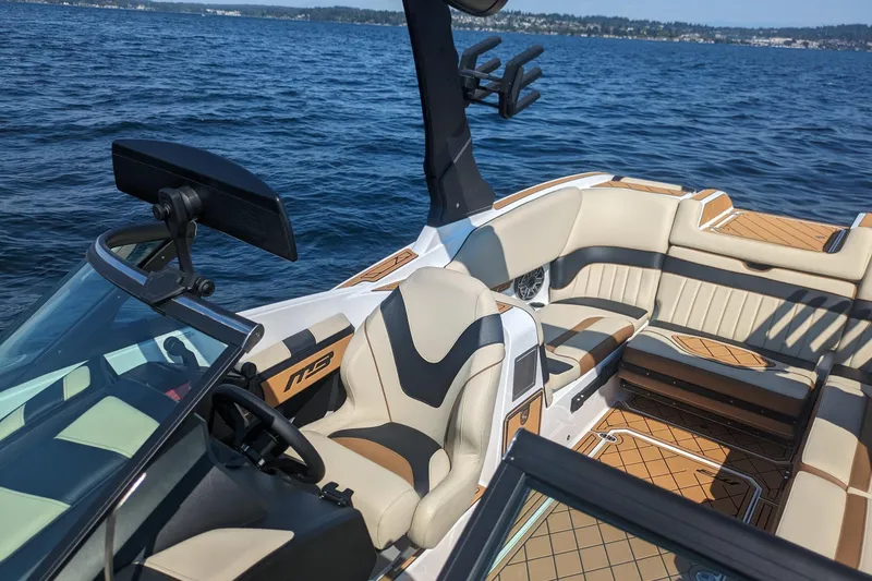 Slide: The Image of Luxurious 2025 MB B52 25 Alpha boat interior with plush seating on a serene lake. - 17