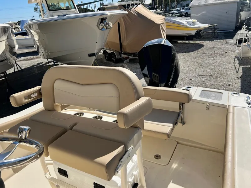 Slide: The Image of 2024 Scout 215 XSF boat interior with beige seating and steering wheel. - 2