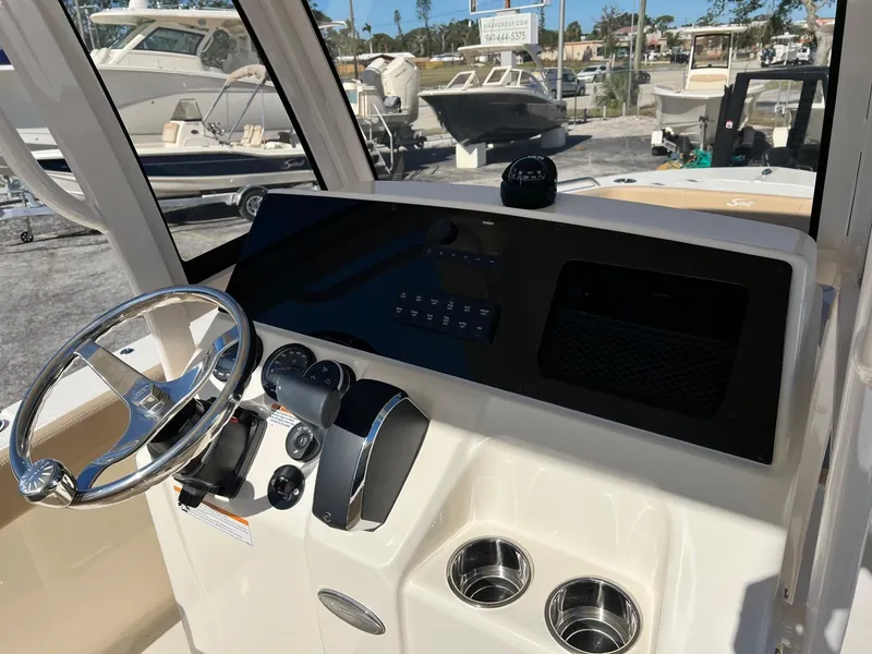 Slide: The Image of 2024 Scout 215 XSF boat dashboard with steering wheel and controls. - 5