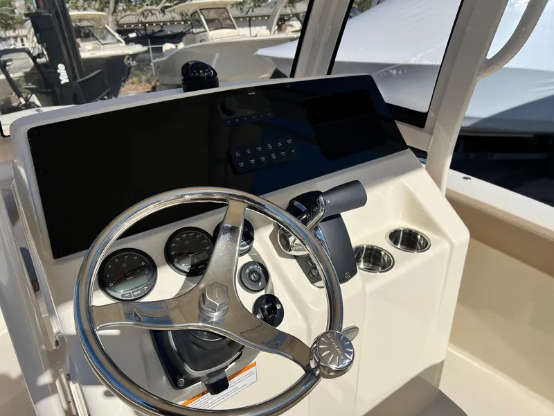Slide: The Image of 2024 Scout 215 XSF boat dashboard with steering wheel and control panel. - 6