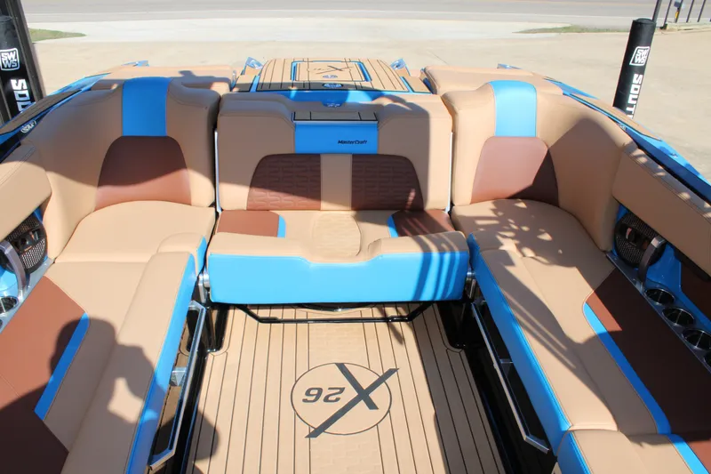 Slide: The Image of 2023 MasterCraft X26 boat interior with tan and blue seating, showcasing luxury design. - 12