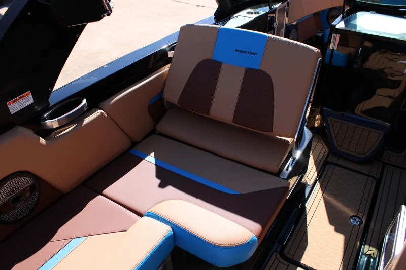 Slide: The Image of 2023 MasterCraft X26 boat interior with brown and blue seating. - 16
