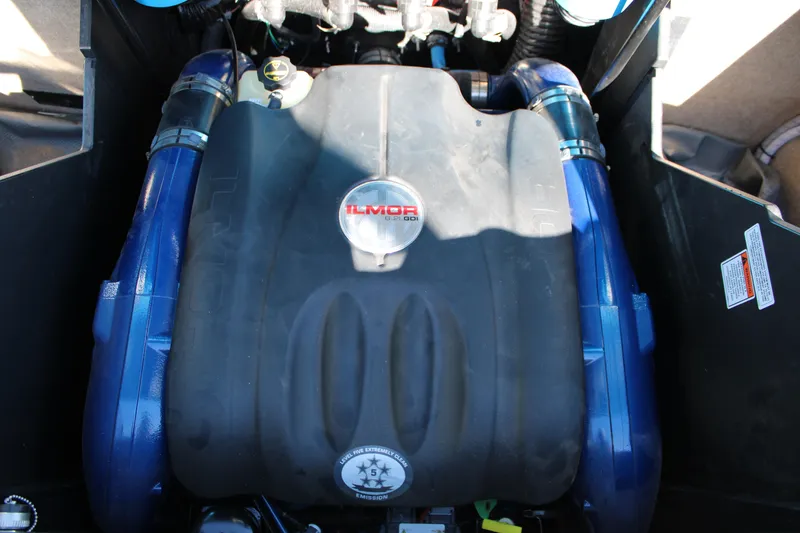 Slide: The Image of 2023 MasterCraft X26 Ilmor engine with blue hoses and black cover. - 24