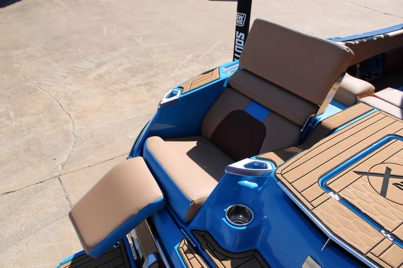 Slide: The Image of 2023 MasterCraft X26 boat with tan seating and blue accents, showcasing luxury design. - 9