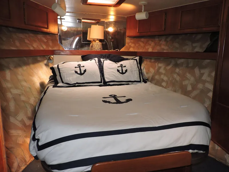 Slide: The Image of Cozy cabin bedroom in 1990 Post 44 boat with nautical-themed bedding. - 36