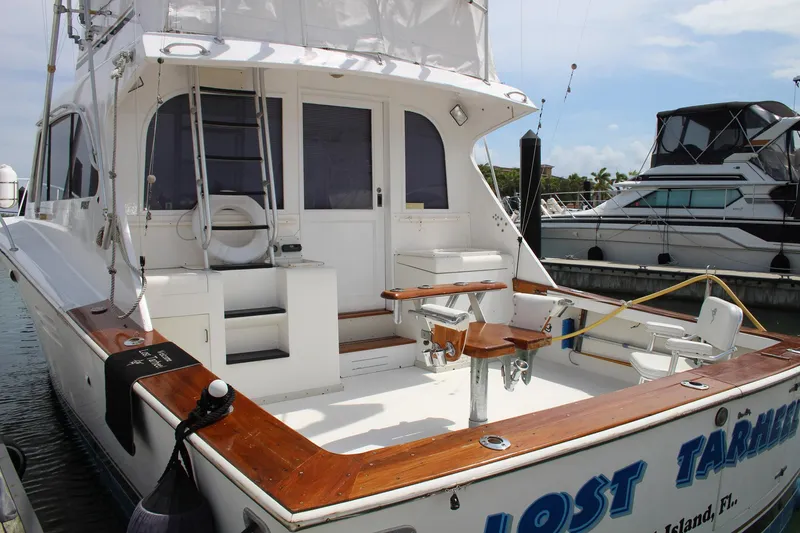 Slide: The Image of 1990 Post 44 yacht docked, featuring spacious deck and seating area. - 4