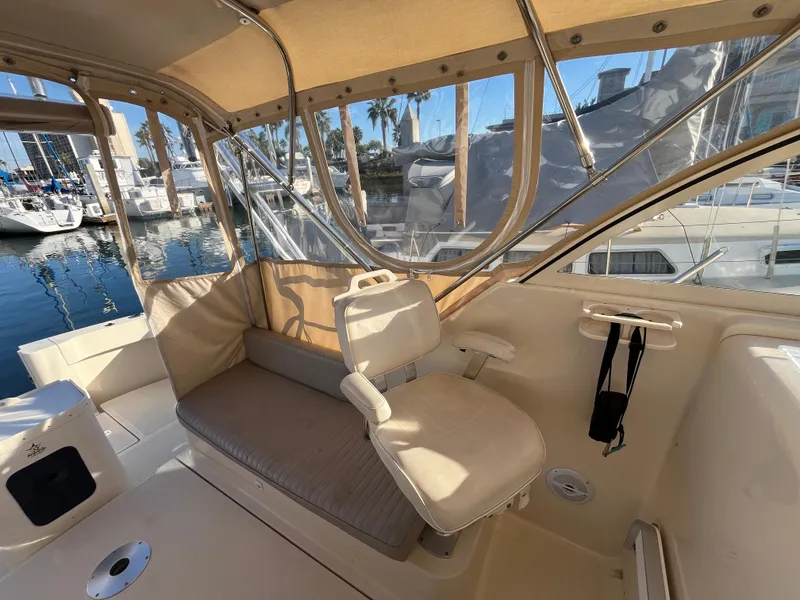 Slide: The Image of 2005 Mainship RumRunner boat interior with seating, docked at marina. - 14