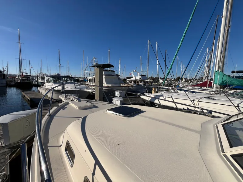Slide: The Image of 2005 Mainship RumRunner docked in a marina with clear blue skies. - 15