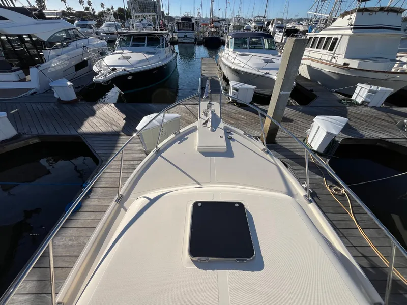 Slide: The Image of 2005 Mainship RumRunner docked at marina, surrounded by other boats. - 16