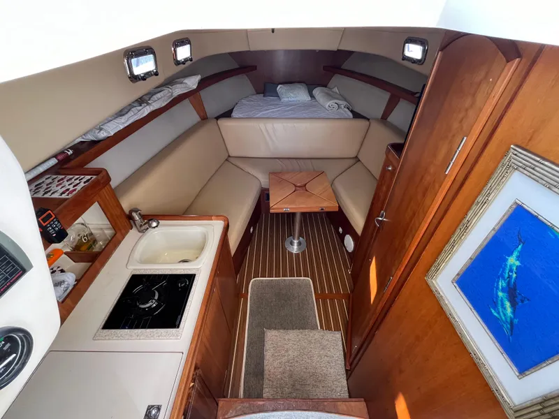Slide: The Image of 2005 Mainship RumRunner cabin interior with kitchenette, seating, and bed. - 22