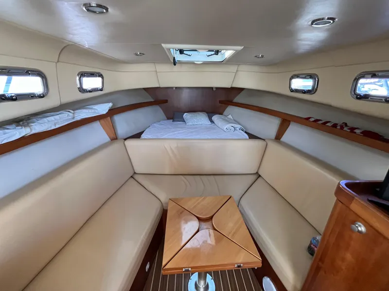 Slide: The Image of 2005 Mainship RumRunner cabin interior with beige seating and wooden accents. - 23