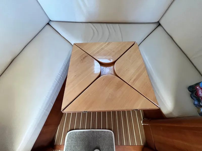 Slide: The Image of 2005 Mainship RumRunner interior with wooden table and white seating. - 24