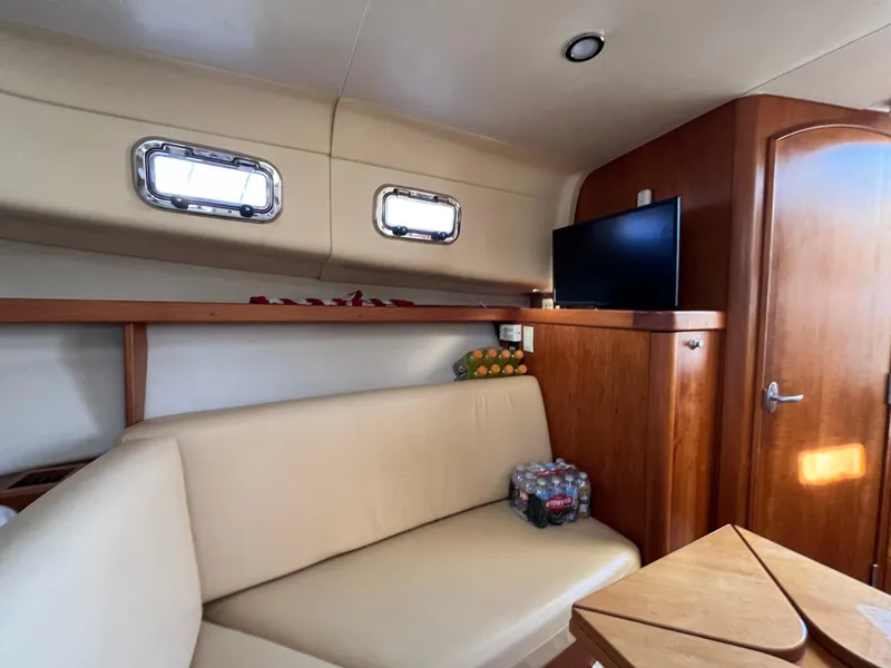 Slide: The Image of 2005 Mainship RumRunner cabin interior with beige seating and wooden accents. - 31