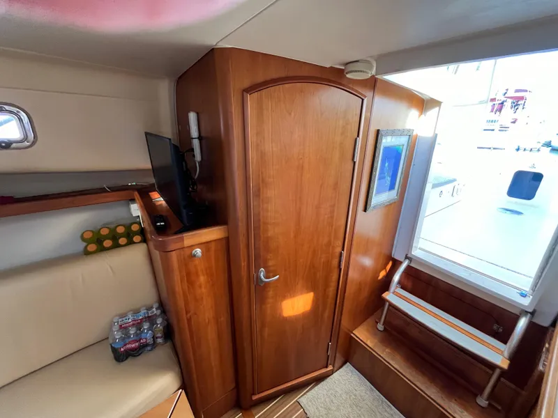 Slide: The Image of 2005 Mainship RumRunner cabin interior with wooden door and seating area. - 33