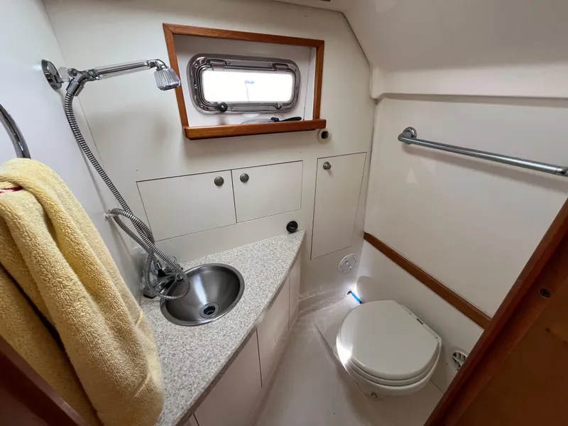 Slide: The Image of 2005 Mainship RumRunner bathroom with sink, toilet, and window. - 34