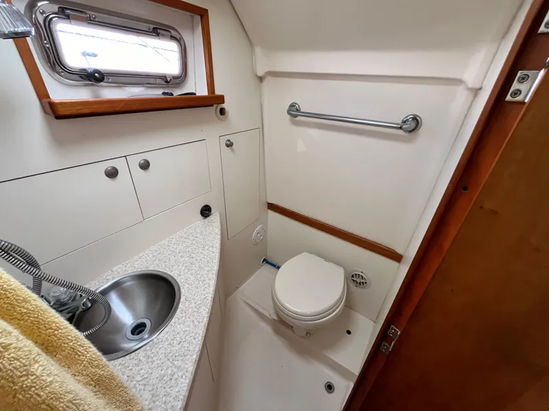 Slide: The Image of 2005 Mainship RumRunner boat bathroom with sink, toilet, and storage cabinets. - 35
