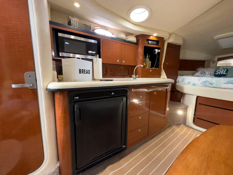 Slide: The Image of Luxurious 2005 Sea Ray 340 Sundancer cabin interior with kitchenette and cozy sleeping area. - 15
