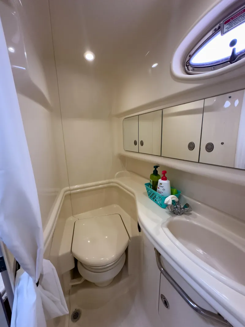 Slide: The Image of 2005 Sea Ray 340 Sundancer bathroom with toilet, sink, and storage cabinets. - 16