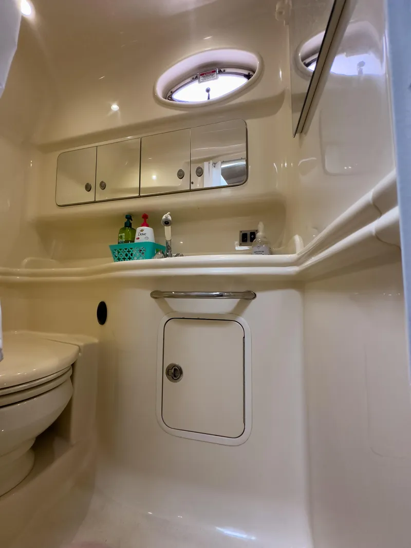 Slide: The Image of 2005 Sea Ray 340 Sundancer bathroom with storage cabinets and porthole windows. - 17