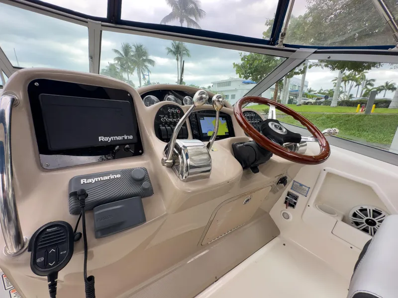 Slide: The Image of 2005 Sea Ray 340 Sundancer helm with Raymarine electronics and wooden steering wheel. - 24