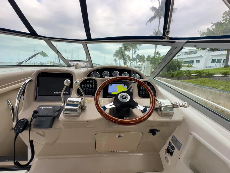 Slide: The Image of 2005 Sea Ray 340 Sundancer helm with steering wheel and navigation controls. - 25