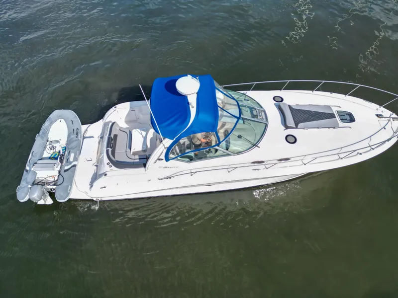 Slide: The Image of 2005 Sea Ray 340 Sundancer yacht with blue canopy cruising on water. - 36